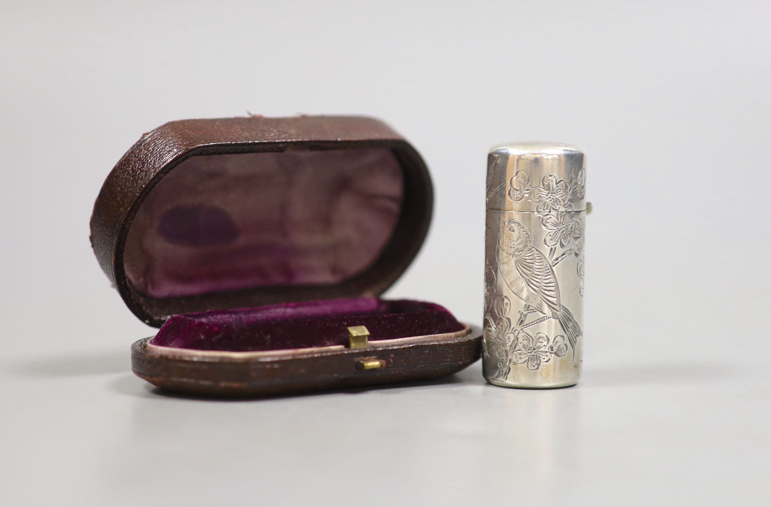 A cased late Victorian silver cylindrical scent bottle, with engraved initials and aesthetic decoration, Sampson Mordan & Co, London, 1882, 53mm.